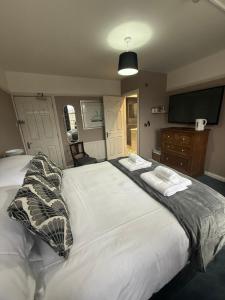 a bedroom with a large bed with pillows and a television at The Endeavour in Whitby