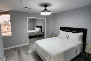 a bedroom with a large white bed and a mirror at Modern High-Rise Apartment - 4 in Tulsa