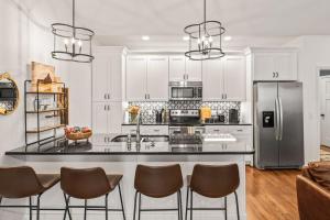 a kitchen with white cabinets and a counter with chairs at Hudgens Court Getaway in Cookeville