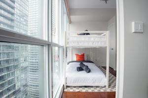 a bedroom with a bunk bed and a large window at 3BR Urban Gem with Scenic Balcony Views in Toronto