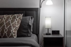 a bedroom with a bed with a lamp and a pillow at Exquisitely Furnished 1BR Suite in DWTN Toronto in Toronto