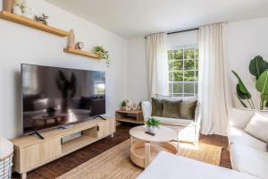 Una sala de estar con un televisor de pantalla plana grande. en Cozy Duplex w King Bed 2 Full, en Maryville
