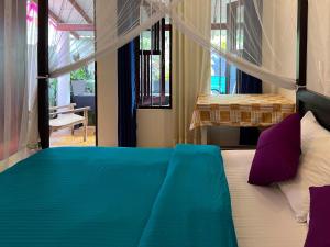 1 dormitorio con cama con sábanas azules y almohadas moradas en Aira Place, en Weligama 11 fotos más