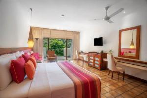 una camera da letto con un letto grande con una scrivania e una televisione di Cinnamon Citadel Kandy a Kandy