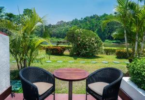 un patio con tavolo e sedie e un giardino di Cinnamon Citadel Kandy a Kandy