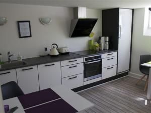 a kitchen with white cabinets and a stove top oven at Ikast Bed & Kitchen in Ikast