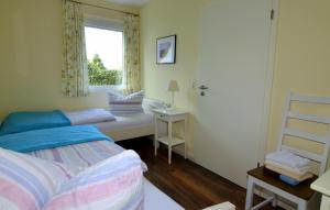 a bedroom with a bed and a window with a chair at Ferienhaus ,Felix' in Heiligenhafen