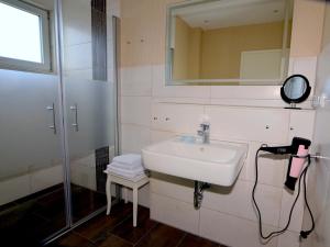 a bathroom with a sink and a mirror and a shower at Ferienhaus ,Felix' in Heiligenhafen +21 photos