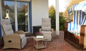 a patio with two chairs and a table and a couch at Ferienhaus ,Felix' in Heiligenhafen