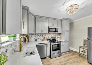 a kitchen with white cabinets and stainless steel appliances at 15% off! Front porch w/ Wi-Fi & Private Parking in Gibsonville