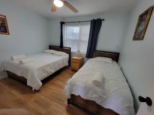 ein Schlafzimmer mit zwei Betten und einem Fenster in der Unterkunft Secret Cajun Retreat Peaceful Corner Stay - HAR 2 in Iowa