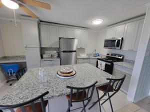 eine Küche mit einer Theke, an der ein Tisch und Stühle stehen in der Unterkunft Secret Cajun Retreat Peaceful Corner Stay - HAR 2 in Iowa