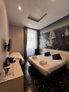 a hotel room with two beds and a painting on the wall at Beverello Rooms in Naples +42 photos