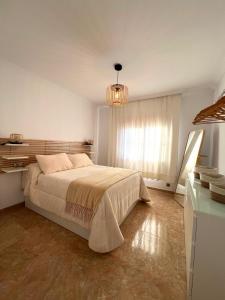 a bedroom with a large bed and a chandelier at Rincón Del Sol in Frigiliana