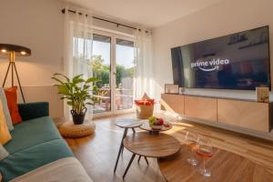 a living room with a couch and a tv at Elegant Eifel Studio I Hiking I Kitchen I Terrace in Daun