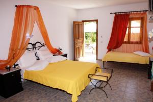 a bedroom with two beds and a chair in it at Artemis Bungalows in Stafylos