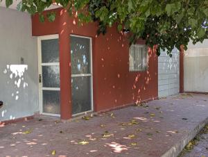 a red building with two windows on the side of it at Departamento Achalay in Chilecito