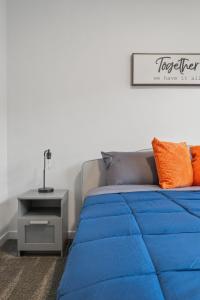 un letto con piumone blu in una camera di Spacious 3 Story Townhome, 2 Car Garage, Sleeps 8, AC, King Bed, 10km from Calgary Downtown, Near Banff a Calgary Altre 66 foto