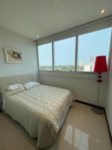 Un dormitorio con una cama y una ventana grande. en Apartment Miami Tower Premium Villa Morra, en Asunción
