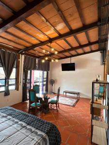 a bedroom with a bed and a table and a tv at Los Cruxes Sam Paz in Tepoztlán