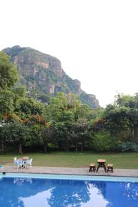 a picnic table and benches next to a swimming pool at Los Cruxes in Tepoztlán