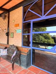 a bench in front of a building with a window at Los Cruxes in Tepoztlán