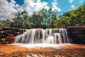 a waterfall in the middle of a forest at Ibiti Village in Lima Duarte