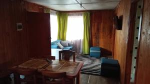 a living room with a table and a couch at Cabañas Ancud Magico in Ancud