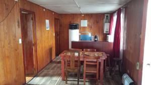a dining room with a wooden table and chairs at Cabañas Ancud Magico in Ancud