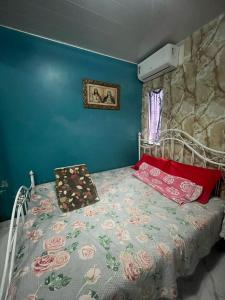 a bed in a room with a blue wall at COP 30 - Casa em São Brás in Belém