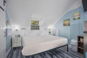 a bedroom with a large white bed and blue walls at Seaside Cottages - Cottage 32B - Seaside One and Too in South Yarmouth