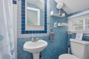 a blue tiled bathroom with a sink and a toilet at Seaside Cottages - Cottage 32B - Seaside One and Too in South Yarmouth