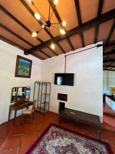 a room with a white wall with a flat screen tv at Los Cruxes in Tepoztlán