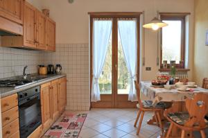 a kitchen with a table and a kitchen with a window at De Bati in Belluno