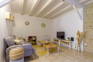 a living room with a couch and a tv at Maison de campagne rénovée proche Argenton Sur creuse in Célon