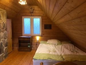 a bedroom with a bed in a wooden cabin at Beskidzka Chatka in Wysowa-Zdrój +7 photos