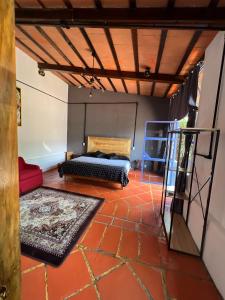 a room with a bed and a rug on a floor at Los Cruxes in Tepoztlán