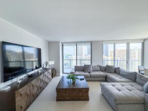 sala de estar con sofá y TV grande en Luxury 3 bedroom condo with pool, en Hallandale Beach