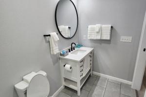 a white bathroom with a sink and a mirror at Urban Hideaway - 201 in Tulsa +14 photos