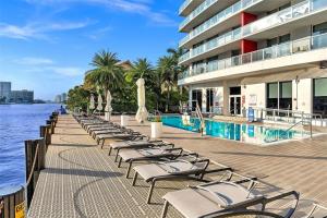 Una fila de tumbonas junto a una piscina. en Luxury 3 bedroom condo with pool, en Hallandale Beach