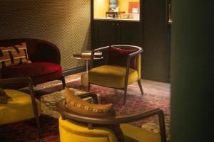 ein Wohnzimmer mit Stühlen, einem Tisch und einem Stuhl in der Unterkunft Leighton House - Boutique Guesthouse in Bath