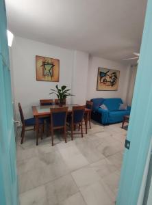 a living room with a table and a blue couch at Hikari&Sineida Home in Rincón de la Victoria