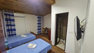 a room with two beds and a table and a mirror at Old Town - Guest House in Stari Bar