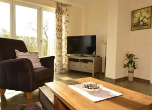 a living room with a television and a coffee table at Ferienhaus ,Anke' in Heiligenhafen