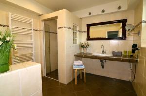 a bathroom with a sink and a shower and a mirror at Ferienhaus ,Anke' in Heiligenhafen +17 photos