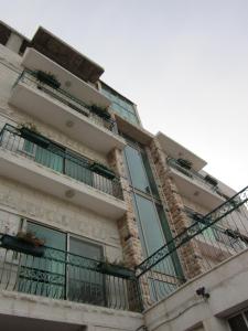 un edificio de apartamentos con balcones y plantas. en Commodore Hotel, en Jerusalén