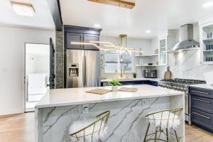 a kitchen with white and blue cabinets and a large island at 6 Mi to Spectrum Center: Spacious Getaway w/ Deck in Charlotte