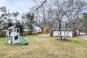 a playground with a slide in a yard with a house at 6 Mi to Spectrum Center: Spacious Getaway w/ Deck in Charlotte
