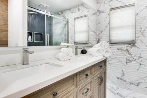 a bathroom with a sink and a mirror at 6 Mi to Spectrum Center: Spacious Getaway w/ Deck in Charlotte +29 photos