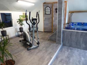 a gym with a treadmill and a swimming pool at Country home with indoor pool 20 pers in Cléguérec